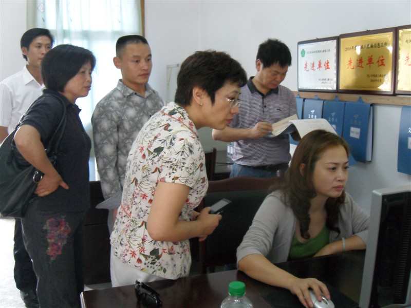 市残联理事长何思伟(后排右)与资中县副县长刘国春在明心寺镇(前排中)