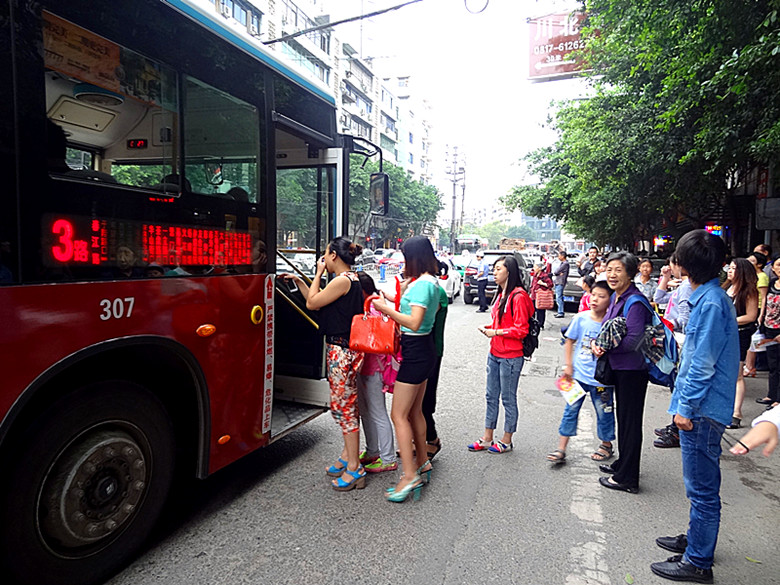 接送學生的小車佔據了公交站臺,公交車在路中心上下客,堵住了跟在後面