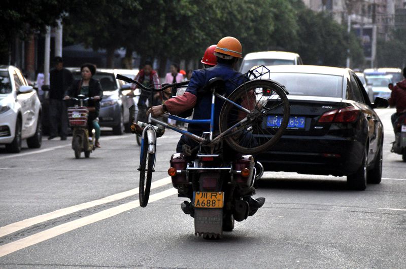 这位仁兄是猛男:摩托车背起自行车在蓬安县城建设路上风驰电掣犹入无