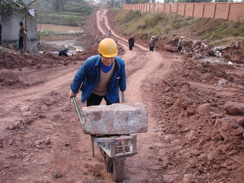 拍摄说明:农民工在扩建火车站工地上搬运石头.