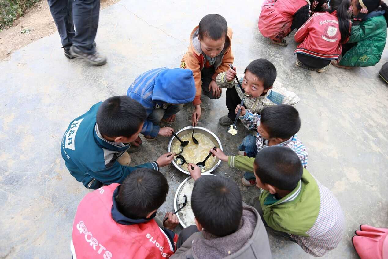 (金子黑老师在为大山里的孩子们盛午饭)