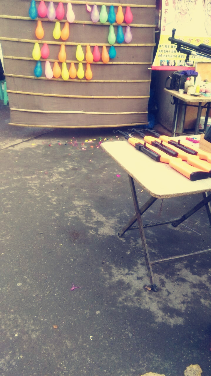 老广场射击摊塑料弹飞溅,过往路人皱眉蹙额怏