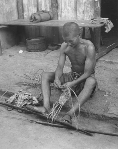 ֣Chinese soldier making his own straw sandals..jpg