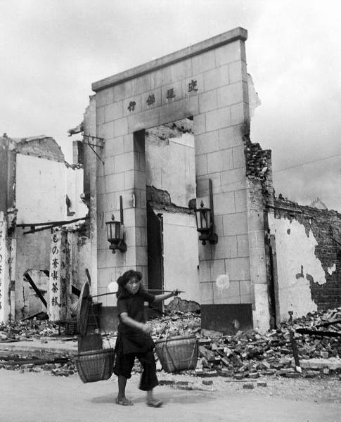 ֣Chinese refugee carrying her possessions upon reentering the city..jpg