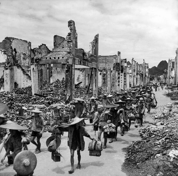 ֣City lying in rubble as troops enter, wearing straw sandles and carrying.jpg